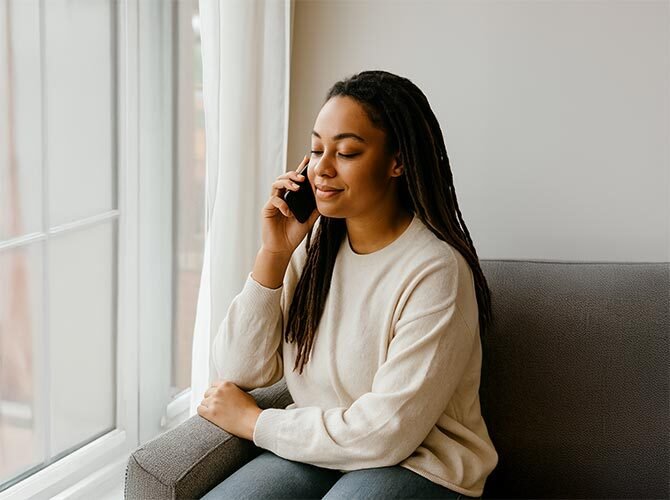 A person reaching out by phone in a quiet room